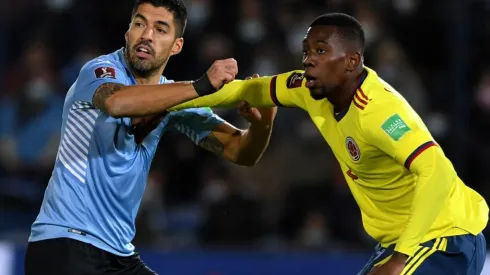 Luis Suarez of Uruguay struggles with Carlos Cuesta of Colombia.