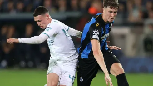 Phil Foden of Manchester City (left) fights for ball possession against Jack Hendry of Club Brugge