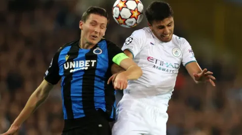 Hans Vanaken of Club Brugge (left) tries to defend a header against Rodrigo of Manchester City