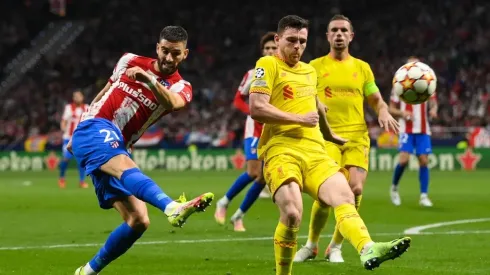 Yannick Carrasco of Atletico de Madrid competes for the ball with James Milner of Liverpool FC during the UEFA Champions League group B match