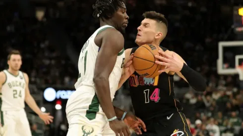 Jrue Holiday of Bucks (left) tries to block pass Tyler Herro of Heat