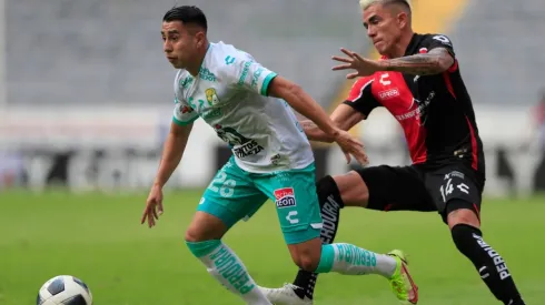 Luis Reyes #14 of Atlas fights for the ball with José Ramírez #28 of Leon.