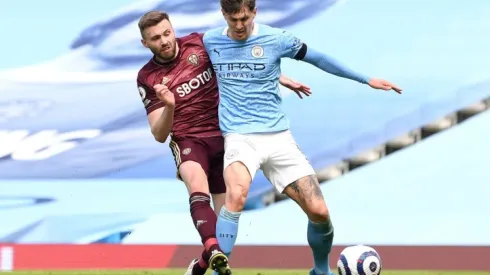 Stuart Dallas of Leeds United (left) fights for ball possession against John Stones of Manchester City