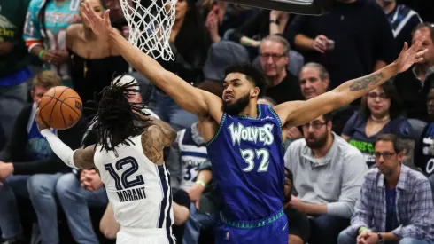Ja Morant of the Memphis Grizzlies goes up for a shot past Karl-Anthony Towns of the Minnesota Timberwolves