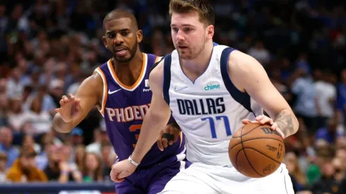 Luka Doncic of the Dallas Mavericks handles the ball as Chris Paul of the Phoenix Suns defends