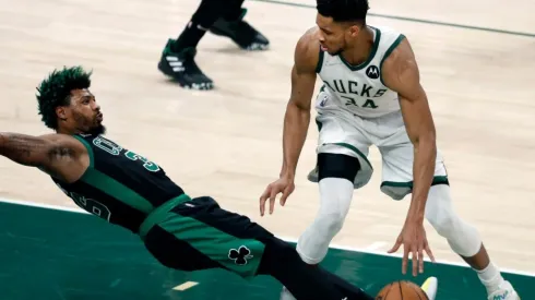 The Bucks Giannis Antetokounmpo (right) was called for a first quarter offensive foul as the Celtics Marcus Smart (left) hits the floor.