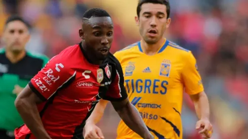 Julian Quiñones of Atlas fights for the ball with Juan Vigon of Tigres UANL