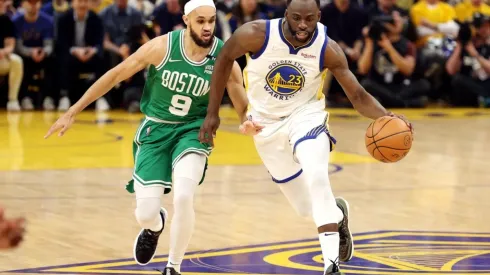 Draymond Green #of the Golden State Warriors dribbles against Derrick White of the Boston Celtics