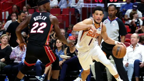 Devin Booker of the Phoenix Suns drives against Jimmy Butler of the Miami Heat