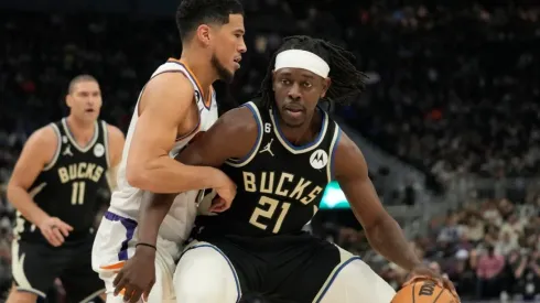Jrue Holiday #21 of the Milwaukee Bucks dribbles the ball against Devin Booker #1 of the Phoenix Suns