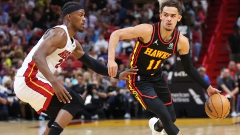 Trae Young dribbles against Jimmy Butler.