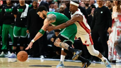 Jayson Tatum #0 of the Boston Celtics controls the ball against Jimmy Butler #22 of the Miami Heat