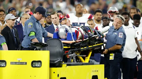 Isaiah Bolden of the Patriots attended by medical staff at Lambeau Field