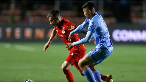 Charles Aránguiz of Internacional battles for possession with Javier Uzeda of Bolivar