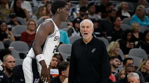 Gregg Popovich head coach of the San Antonio Spurs confers with Charles Bediako