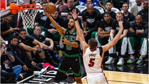 The Boston Celtics Jayson Tatum (0) lays up the ball while defended by the Miami Heat's Nikola Jovic