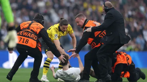Marcel Sabitzer of Borussia Dortmund assists members of security as they stop a pitch invader during the UEFA Champions League 2023/24 Final match between Borussia Dortmund and Real Madrid CF at Wembley Stadium on June 01, 2024 in London, England.