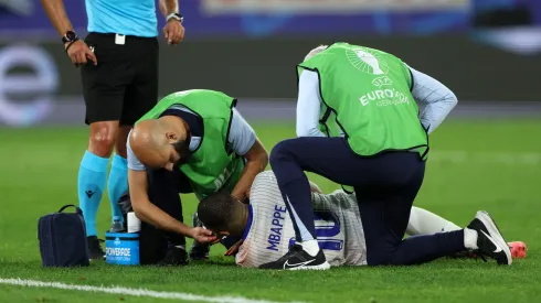 Kylian Mbappe of France receives medical treatment after clashing heads with Kevin Danso of Austria (not pictured) during the UEFA EURO 2024 group stage match between Austria and France at Düsseldorf Arena on June 17, 2024 in Dusseldorf, Germany.