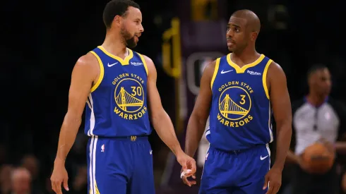 Stephen Curry #30 and Chris Paul #3 of the Golden State Warriors talk after a stop in play against the Los Angeles Lakers during the first half in a preseason game.