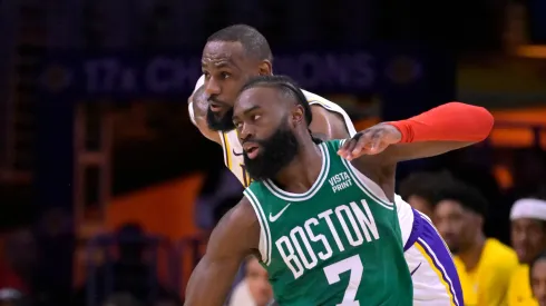 LeBron James #23 of the Los Angeles Lakers collides with Jaylen Brown #7 of the Boston Celtics in the first half at Crypto.com Arena on December 25, 2023 in Los Angeles, California.