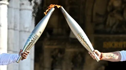 Claudia Tagbo, French-Ivorian actress and comedian and Pascal Touitou carry the Olympic Torch at Basilique du Sacre-Coeur de Montmartre during the second day of the Paris 2024 Olympic Torch Relay on July 15, 2024 in Paris, France.