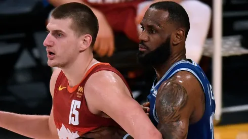 Nikola Jokic #15 of the Denver Nuggets is guarded by LeBron James #23 of the Los Angeles Lakers during the first half at Staples Center.