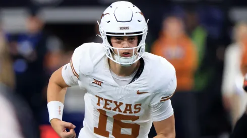 Quarterback Arch Manning #16 of the Texas Longhorns runs behind the line against the Oklahoma State Cowboys in the second half of the Big 12 Championship at AT&T Stadium on December 2, 2023 in Arlington, Texas.