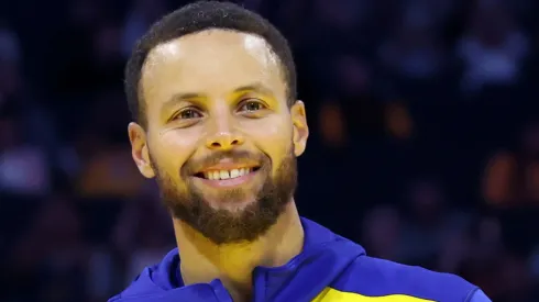 Jonnie West, the Warriors senior director of pro player personnel and son of Jerry West, presents Stephen Curry #30 of the Golden State Warriors the Jerry West Trophy as the Kia NBA Clutch Player of the Year last season before their preseason game against the Los Angeles Lakers at Chase Center on October 18, 2024 in San Francisco, California.