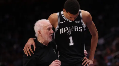 Head coach Gregg Popovich of the San Antonio Spurs talks to Victor Wembanyama #1 during the second half while playing the Detroit Pistons at Little Caesars Arena on January 10, 2024 in Detroit, Michigan.