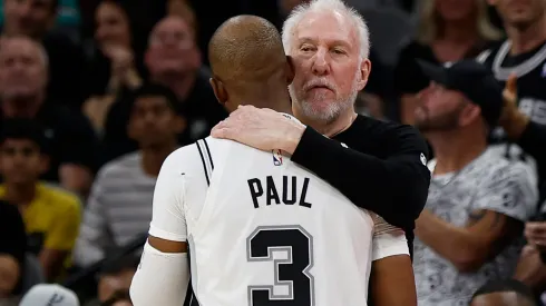 Chris Paul #3 of the San Antonio Spurs gets a hug from Head coach Gregg Popovich after an assist against the Houston Rockets in the first half at Frost Bank Center on October 26, 2024 in San Antonio, Texas.