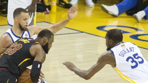 LeBron James 23 of the Cleveland Cavaliers drives against Stephen Curry 30 and Kevin Durant 35 of the Golden State Warriors during their NBA Basketball Herren USA Championship Game 1 at Oracle Arena in Oakland
