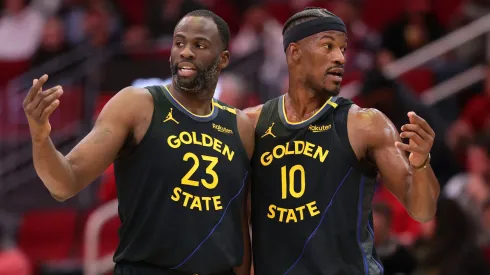 Draymond Green #23 and Jimmy Butler #10 of the Golden State Warriors speak on the court against the Houston Rockets during the first half at Toyota Center on February 13, 2025 in Houston, Texas.