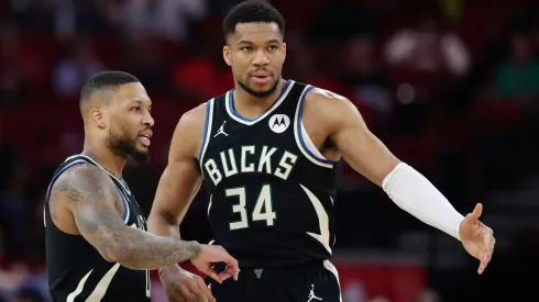 Damian Lillard #0 and Giannis Antetokounmpo #34 of the Milwaukee Bucks speak on the court during the first half against the Houston Rockets.