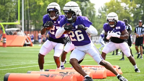 Kene Nwangwu #26 and DeWayne McBride #27 of the Minnesota Vikings run a drill during a joint training camp practice with the Cleveland Browns at CrossCountry Mortgage Campus in 2024.