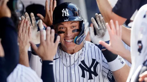 Aaron Judge #99 of the New York Yankees celebrates his seventh inning two run home run against the Athletics with his teammates in the dugout at Yankee Stadium on June 29, 2025 in New York City.