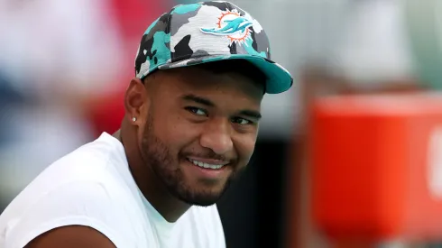 Tua Tagovailoa #1 of the Miami Dolphins looks on from the bench prior to a game against the Philadelphia Eagles at Hard Rock Stadium on August 27, 2022 in Miami Gardens, Florida.