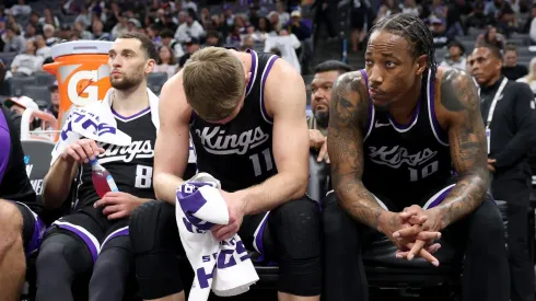 DeMar DeRozan #10, Domantas Sabonis #11, and Zach LaVine #8 of the Sacramento Kings sit.