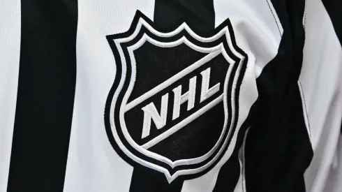 A closeup view of the NHL crest is seen on a referee jersey.