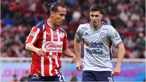 Fernando Gonzalez of Chivas controls the ball ahead of Jose Paradela of Cruz Azul