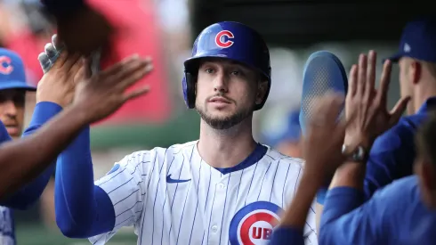 Kyle Tucker #30 of the Chicago Cubs high-fives teammates in the dugout.