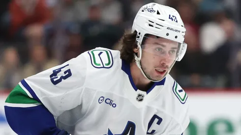 Quinn Hughes #43 with the Canucks controls the puck.