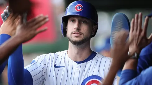 Kyle Tucker #30 with the Cubs high-fives teammates in the dugout.