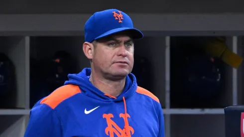 New York Mets manager Carlos Mendoza looks on from the dogout.