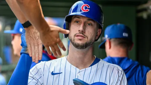 Kyle Tucker #30 with the Chicago Cubs high fives teammates after scoring.