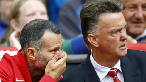 MURMULLOS. Giggs le habla al oído al van Gaal en Old Trafford durante su etapa de asistente técnico.