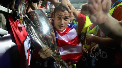 CARIÑO DE CAMPEÓN. Griezmann lleva la Supercopa de Europa entre los hinchas del Atlético Madrid (Foto: Getty).