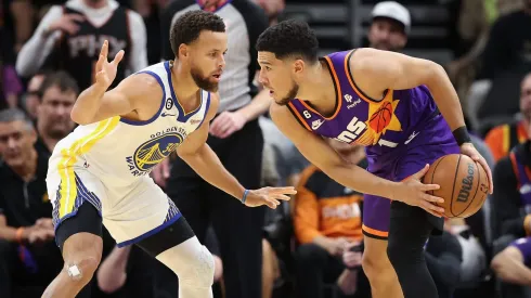 Stephen Curry defendiendo a Devin Booker.