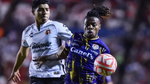 Víctor Guzmán, del Tijuana, persigue a Jhon Murillo, del Atlético de San Luis.