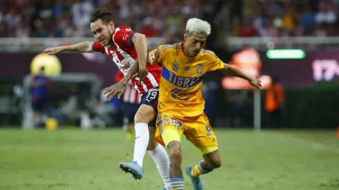 ZAPOPAN, MEXICO - SEPTEMBER 13: Jesús Angulo of Chivas fights for the ball with Raymundo Fulgencio of Tigres during the 9th round match between Chivas and Tigres UANL as part of the Torneo Apertura 2022 Liga MX at Akron Stadium on September 13, 2022 in Zapopan, Mexico. (Photo by Refugio Ruiz/Getty Images)