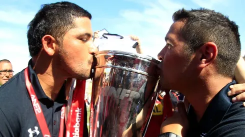 Miguel Riffo besando la copa de campeón del Clausura 2014 junto a Héctor Tapia.